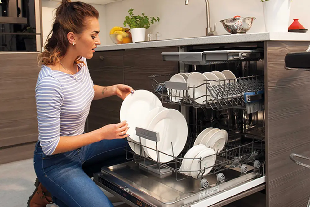 Máy giặt hoặc máy rửa chén được chất đầy đồ, chuẩn bị cho một chu trình hoạt động