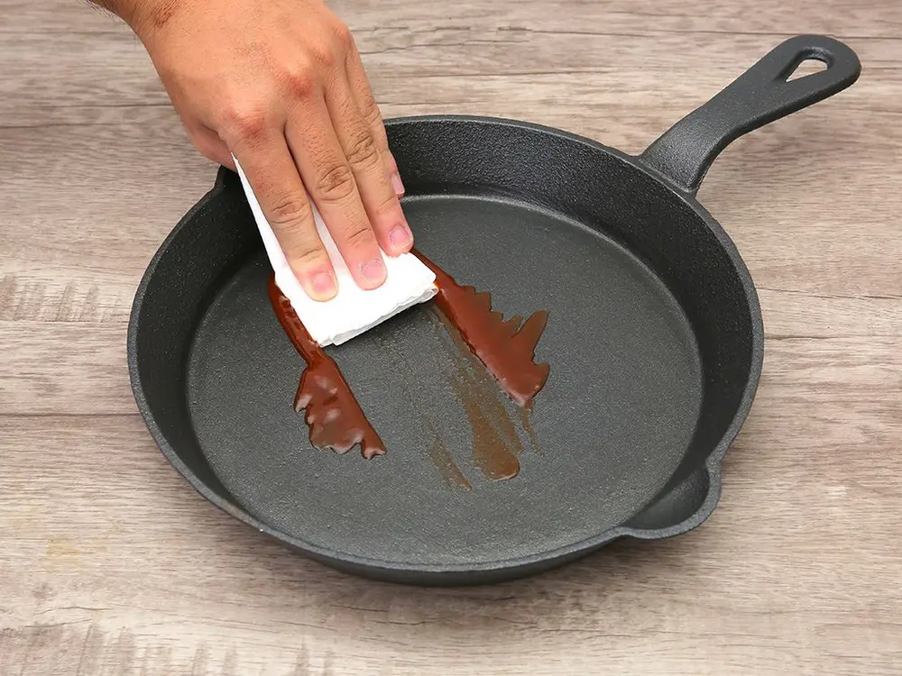 Vệ sinh chảo gang ngay sau khi sử dụng giúp loại bỏ cặn thức ăn dễ dàng và bảo vệ lớp chống dính